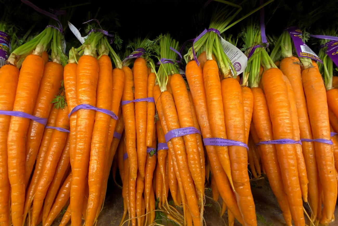 Fresh orange carrots lie in bunches side by side for sale at a grocery store in Del Mar, California, on June 3, 2020.