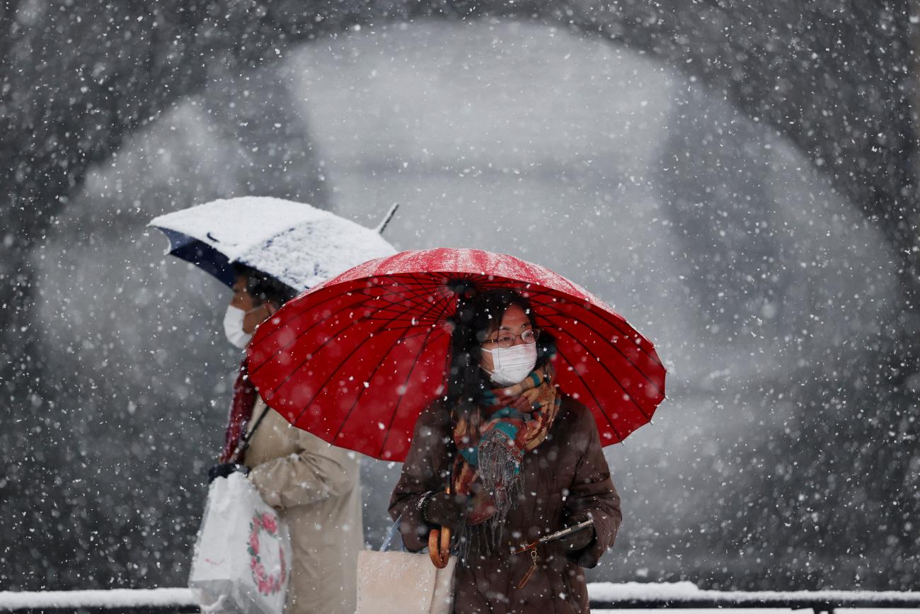 People wearing protective face masks visit the snow-covered Imperial Palace, amid the coronavirus disease (COVID-19) pandemic, in Tokyo, Japan January 6, 2022. REUTERS/Issei Kato