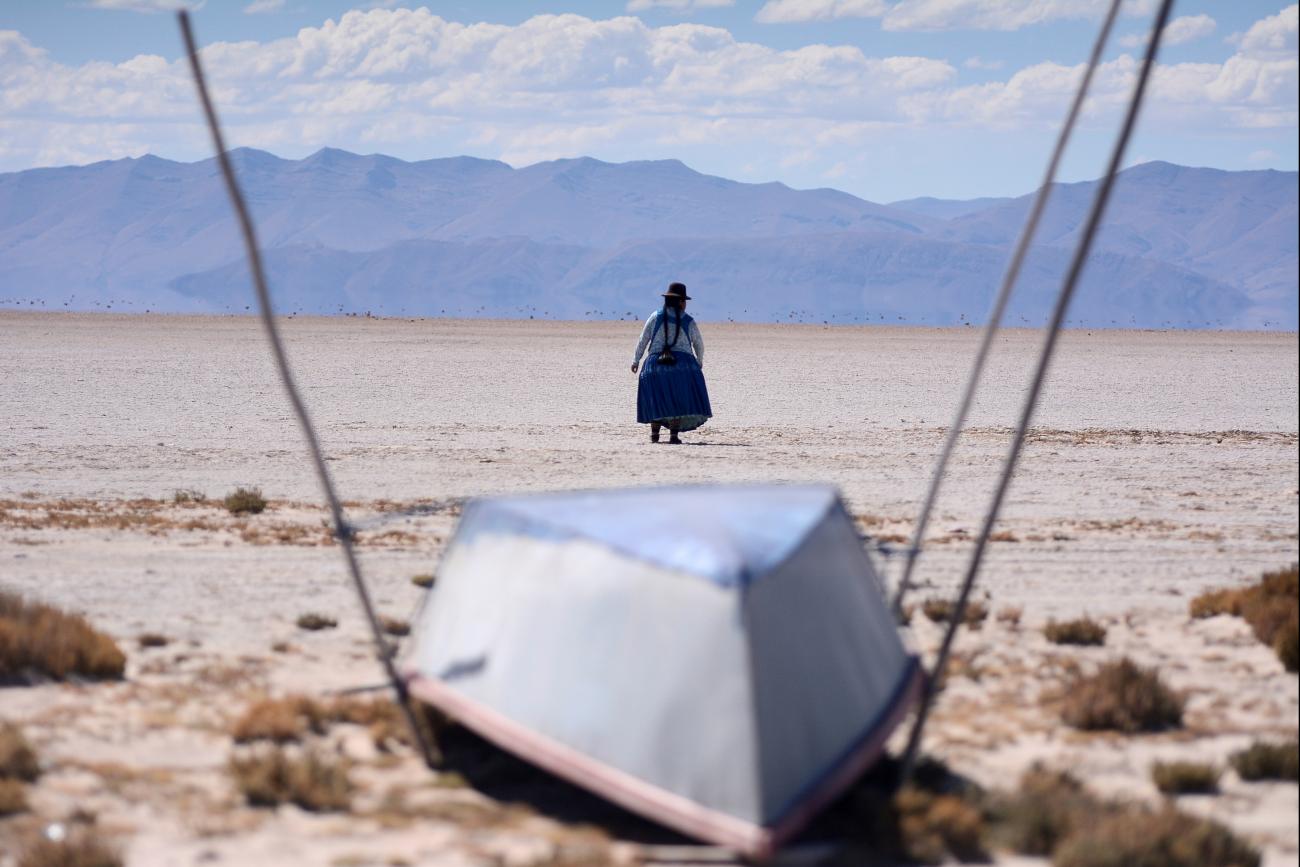 Cristina Mamani walks in dried up Lake Poopo, Bolivia—brought on by a warmer, drier climate, say local residents and scientists. Photo taken July 24, 2021. 