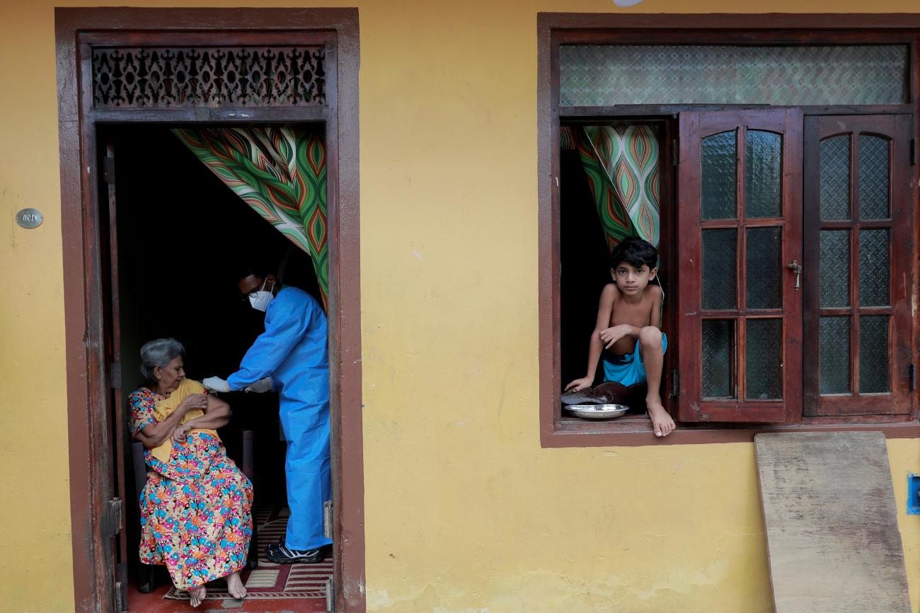 An elderly woman receives a dose of Sinopharm vaccine at her home from the Sri Lanka Army mobile vaccination unit against the coronavirus disease (COVID-19) in Colombo, Sri Lanka, September 14, 2021