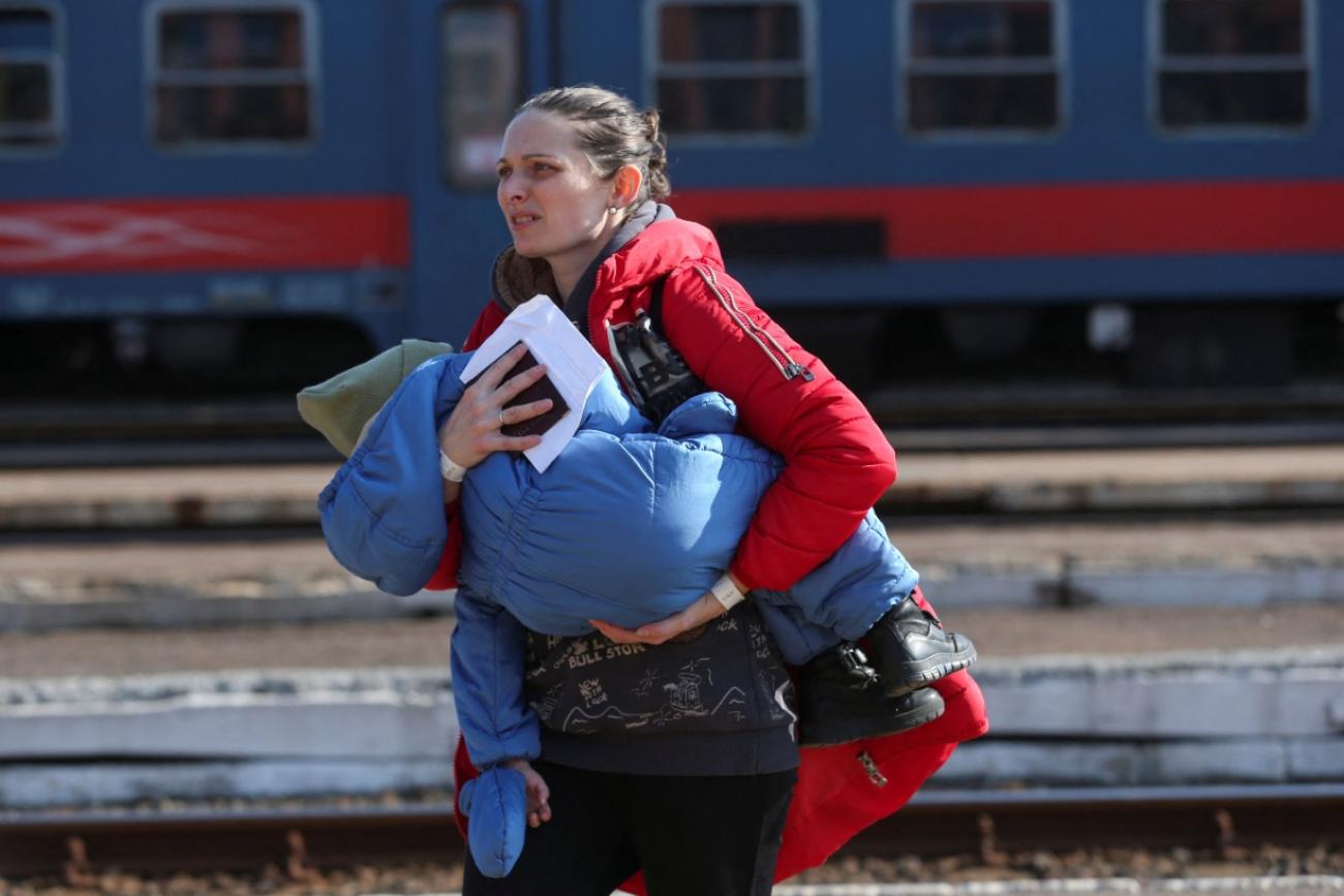 A woman fleeing Russia's invasion of Ukraine carries a child at the train station in Zahony, Hungary March 6, 2022. 