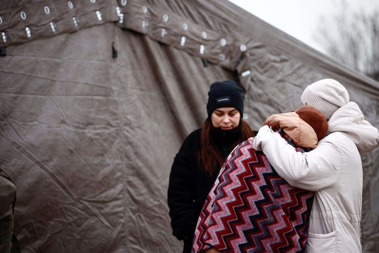 Women fleeing the Russian invasion of Ukraine, stay outside a tent at a temporary camp in Przemysl, Poland, March 2, 2022