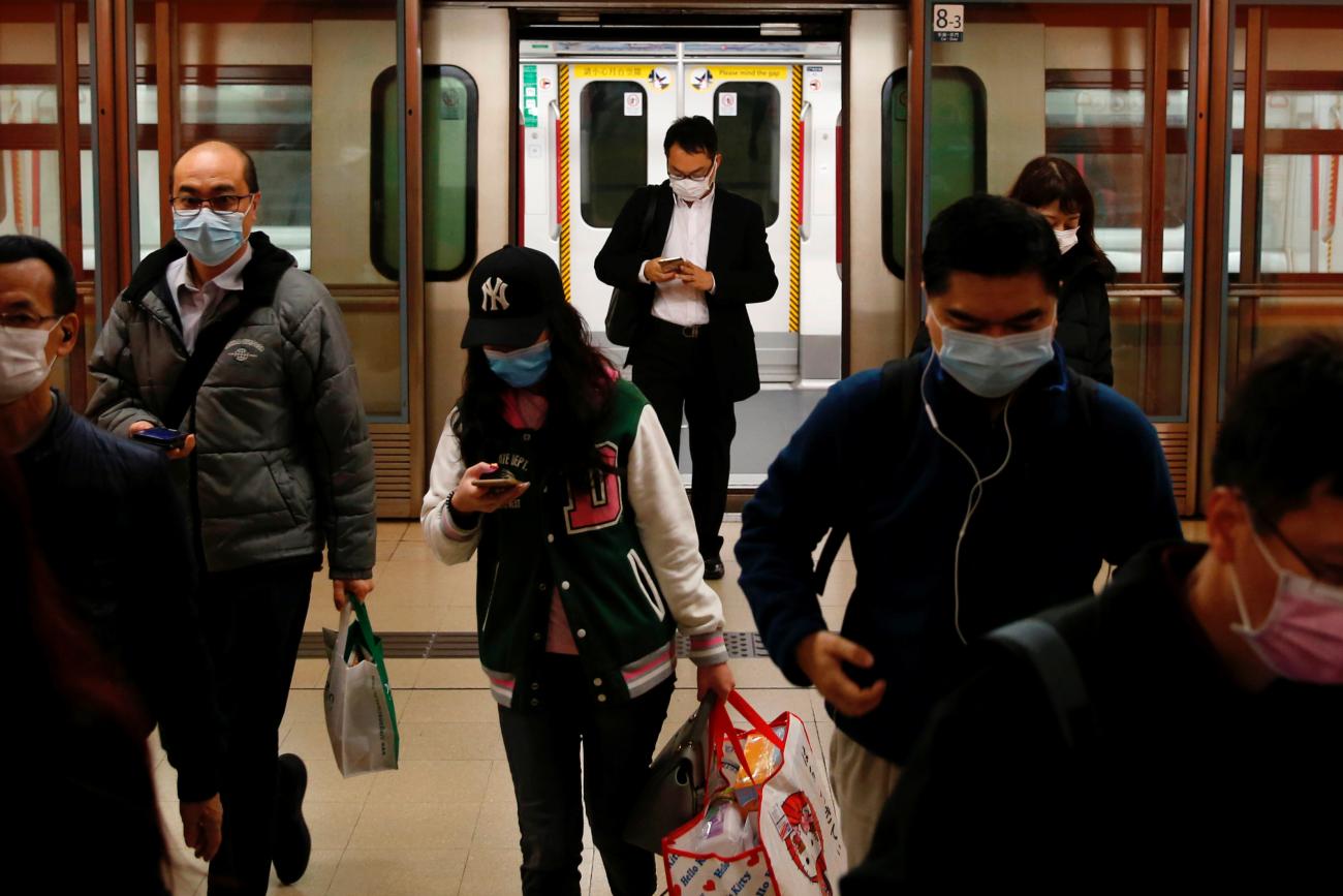 People wear protective masks following the outbreak of a new coronavirus, during their morning commute in a station, in Hong Kong, China