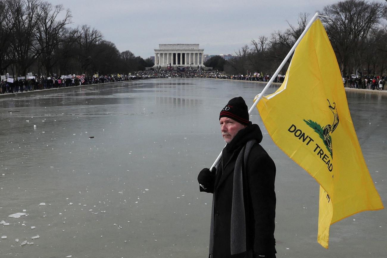 A man holds a flag during a march in opposition to coronavirus disease (COVID-19) mandates on the National Mall in Washington, D.C