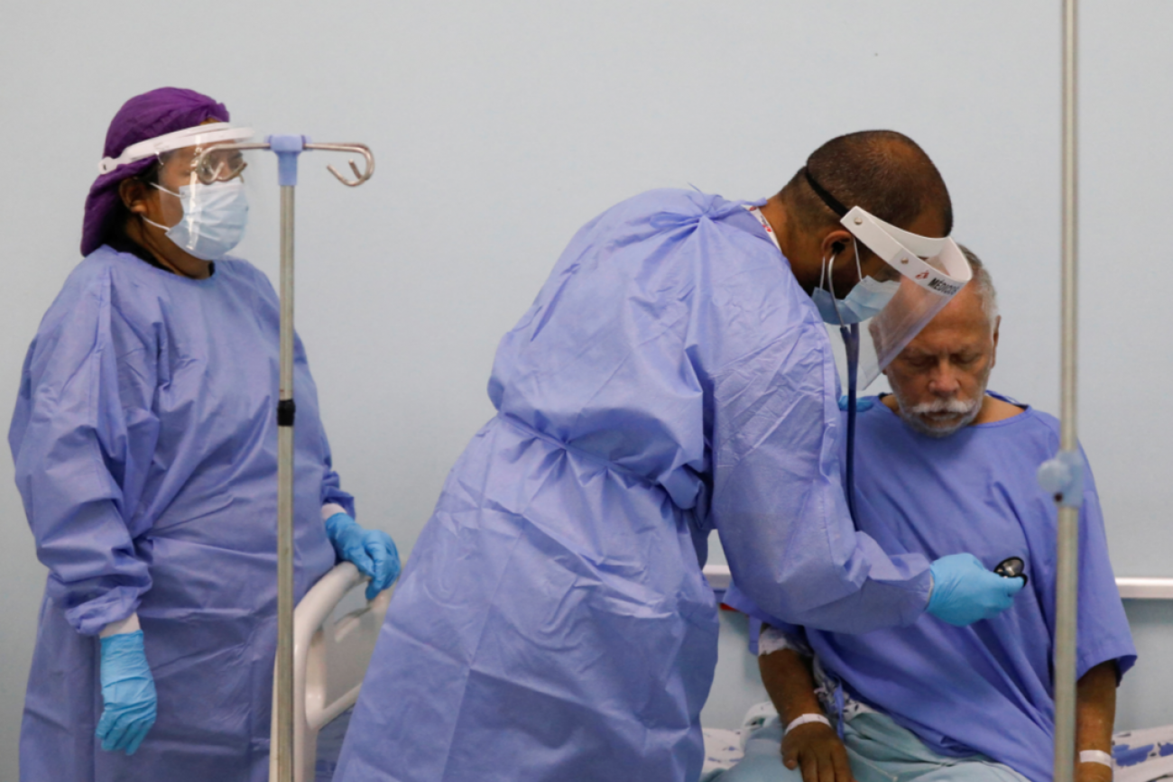 A physician with Doctors Without Borders (MSF) places his stethoscope to the chest of hospital patient Marco Vargas, who has COVID, in Caracas, Venezuela, on February 1, 2022. 