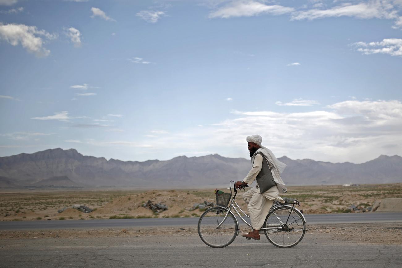 An Afghan man rides a bicycle on the outskirts of Kabul, Afghanistan, on July 30, 2015.