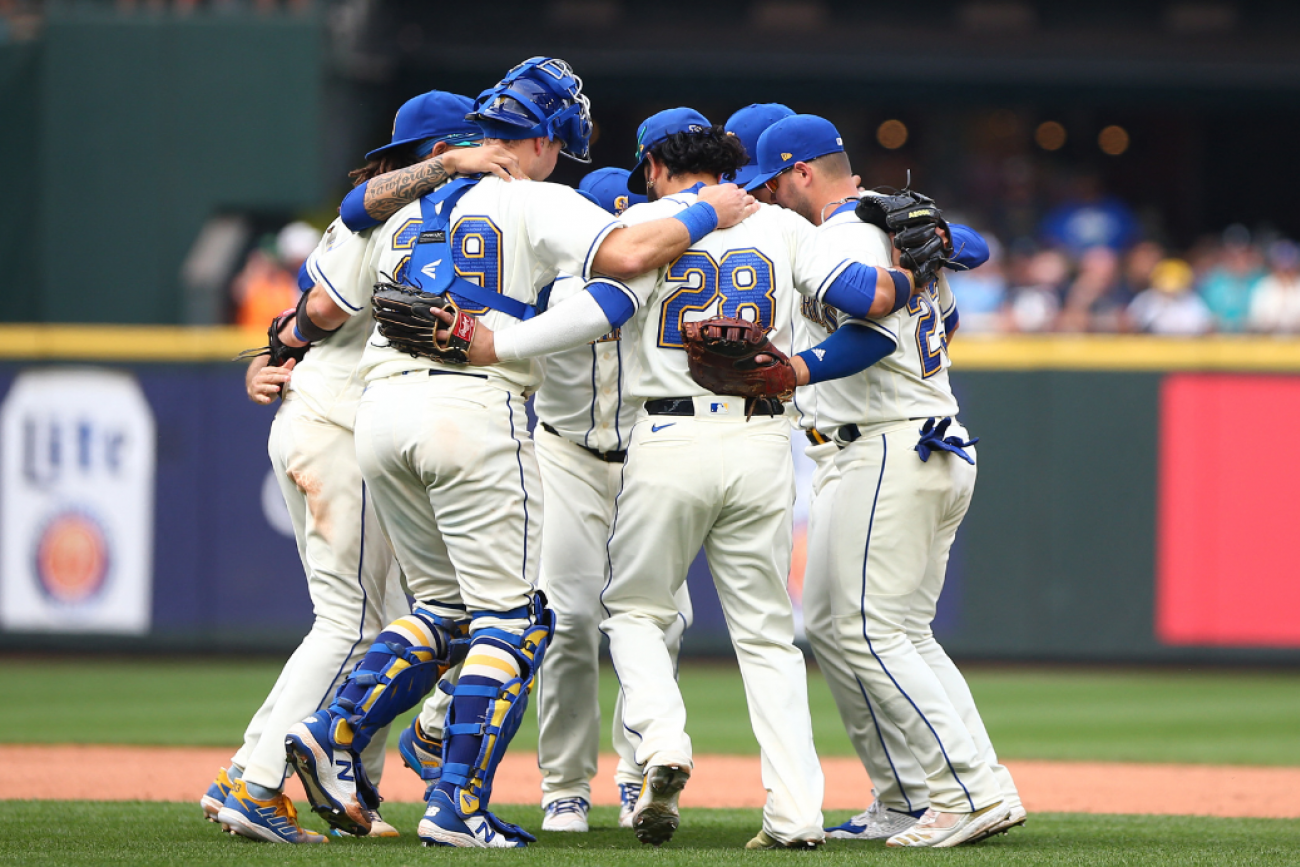 Seattle Mariners infielders hug and dance as they celebrate beating the San Diego Padres 6-1, at T-Mobile Park, in Seattle, Washington, on September 14, 2022.