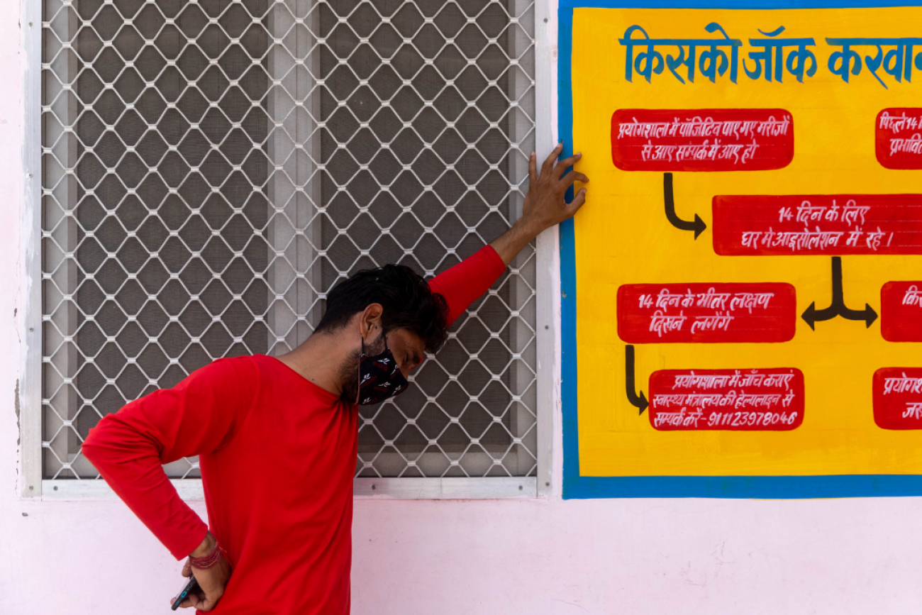 A man in a red shirt stands in profile and weeps as his mother is being treated inside a COVID-19 intensive care unit of a government-run hospital, amidst the coronavirus pandemic, in Bijnor District, Uttar Pradesh, India, on May 11, 2021. Photo by REUTERS/Danish Siddiqui