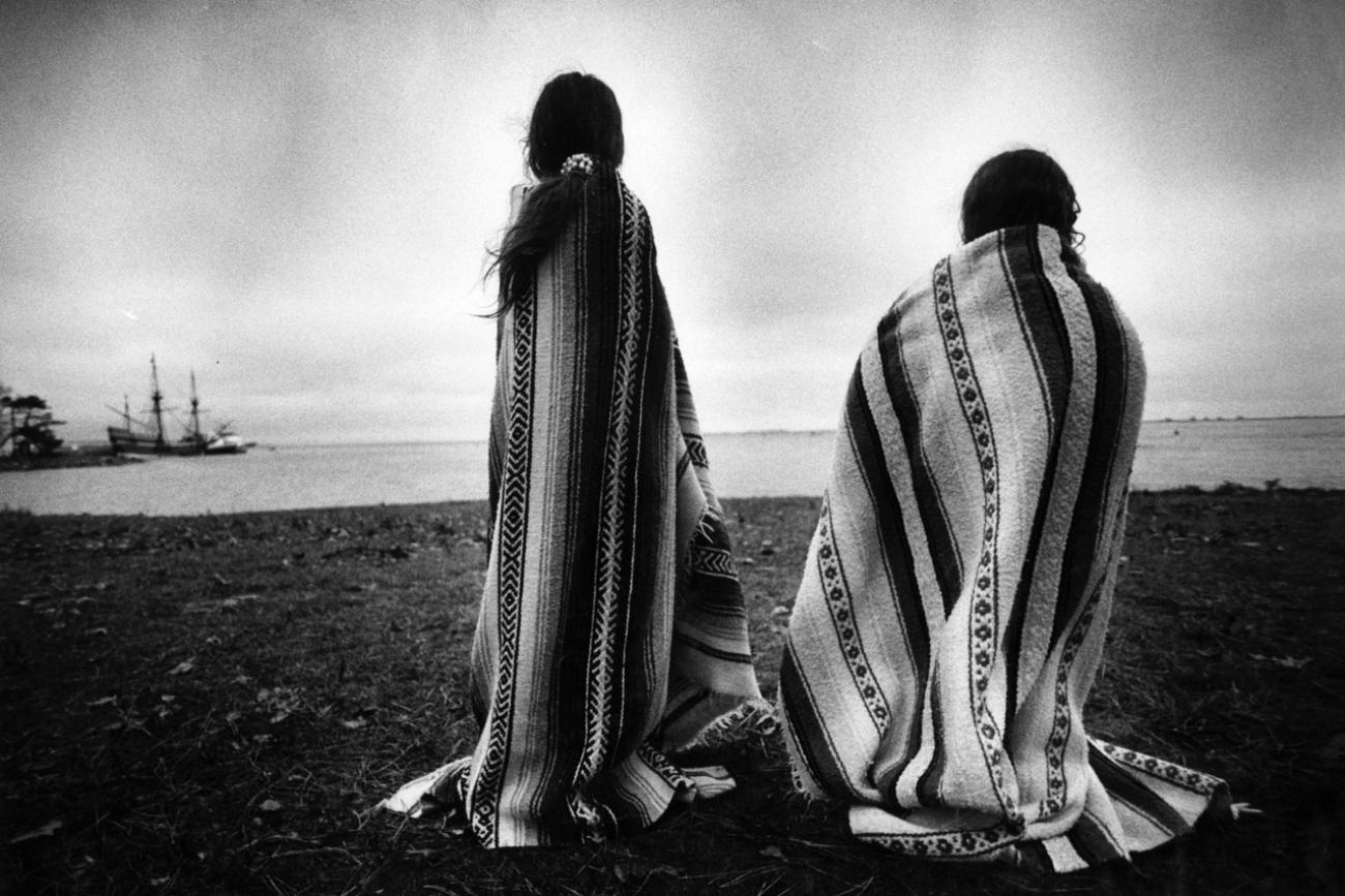 Weetoomoo Carey, 8, left, and her sister Jackolynn Carey, 5, Wampanoag Nipmucs from Mashpee, look across to the Mayflower replica anchored near Plymouth Rock in Plymouth, Mass. on Nov. 26, 1991. 