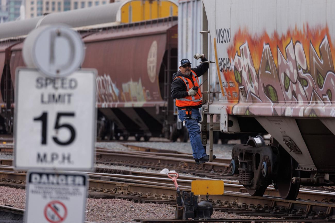 A railway worker helps load railcars onto a train in San Diego, California, U.S., November 30, 2022.