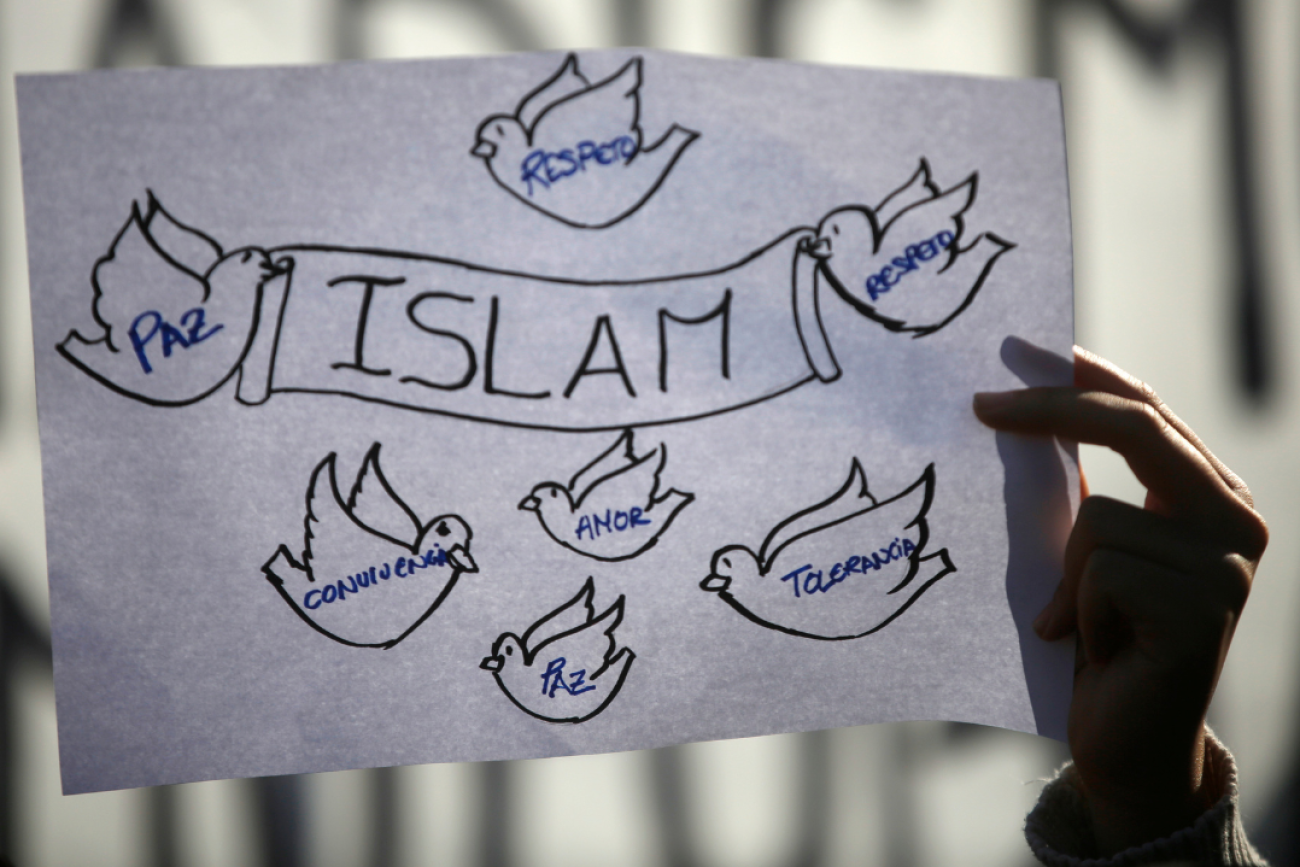 A girl holds a sign on a white piece of paper at a rally against Islamophobia in Madrid, Spain, January 2015. The words on the birds say, "Peace, Respect, Love, Tolerance, and Coexistence.”