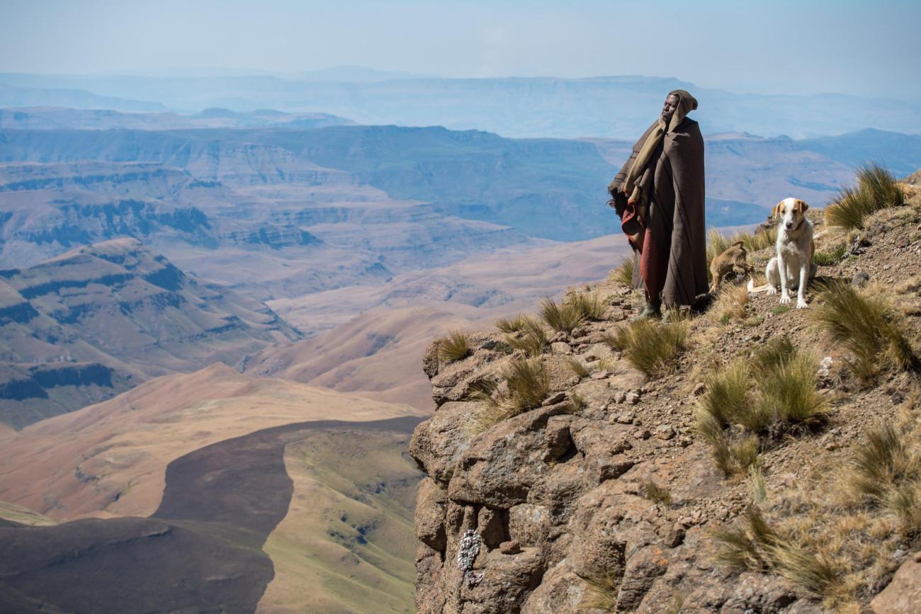 Basotho shepherd and dog looking out from a mountain ledge, in Thaba Tseka, Lesotho. Photo courtesy of Edwin Remsberg