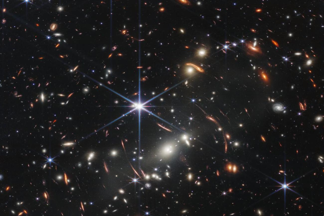 Thousands of galaxies flood this near-infrared image of galaxy cluster SMACS 0723. High-res imaging from NASA’s James Webb Space Telescope and gravitational lensing made the image possible. 