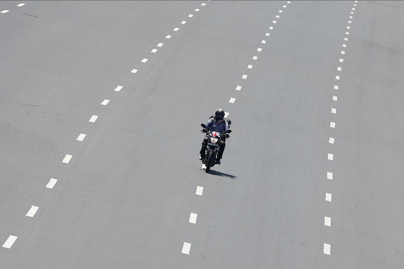 Delivery worker Devender Singh, who works for Licious, an online meat store, rides his bike on a deserted road, in New Delhi, India, on April 6, 2020.