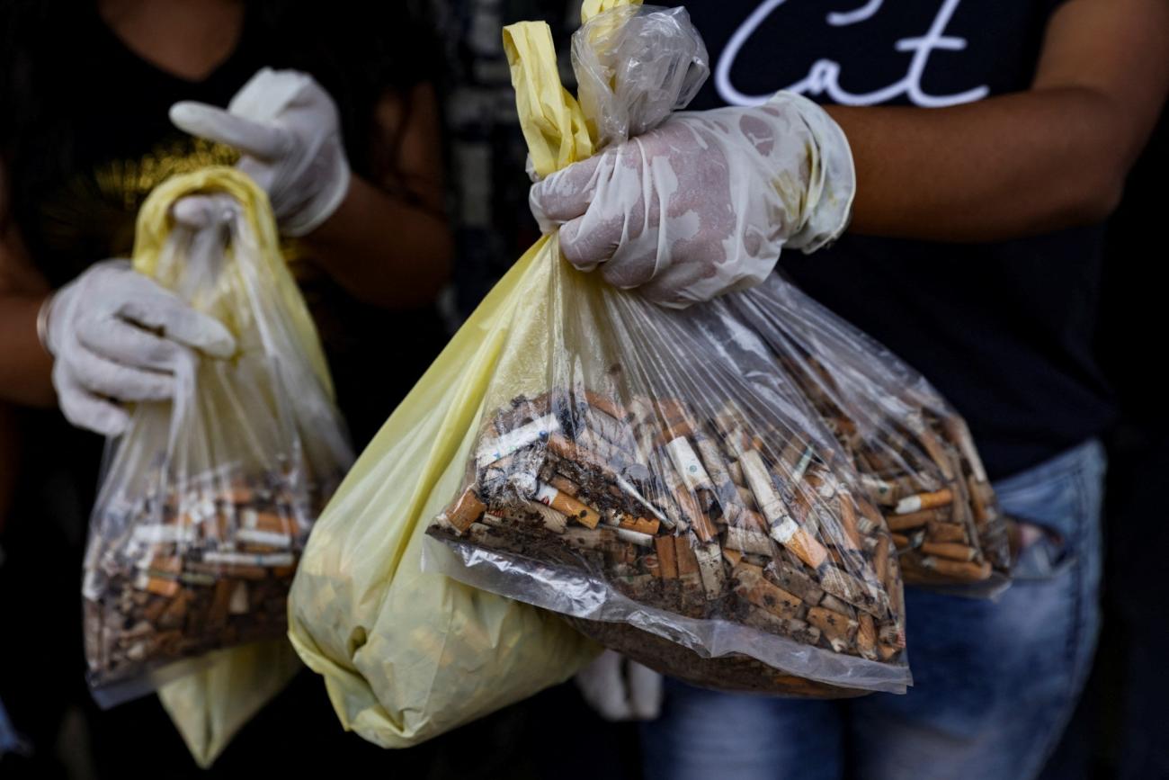 College students show their collected cigarette filter tips to be used for recycling during a collection drive in New Delhi, India, September 14, 2022.