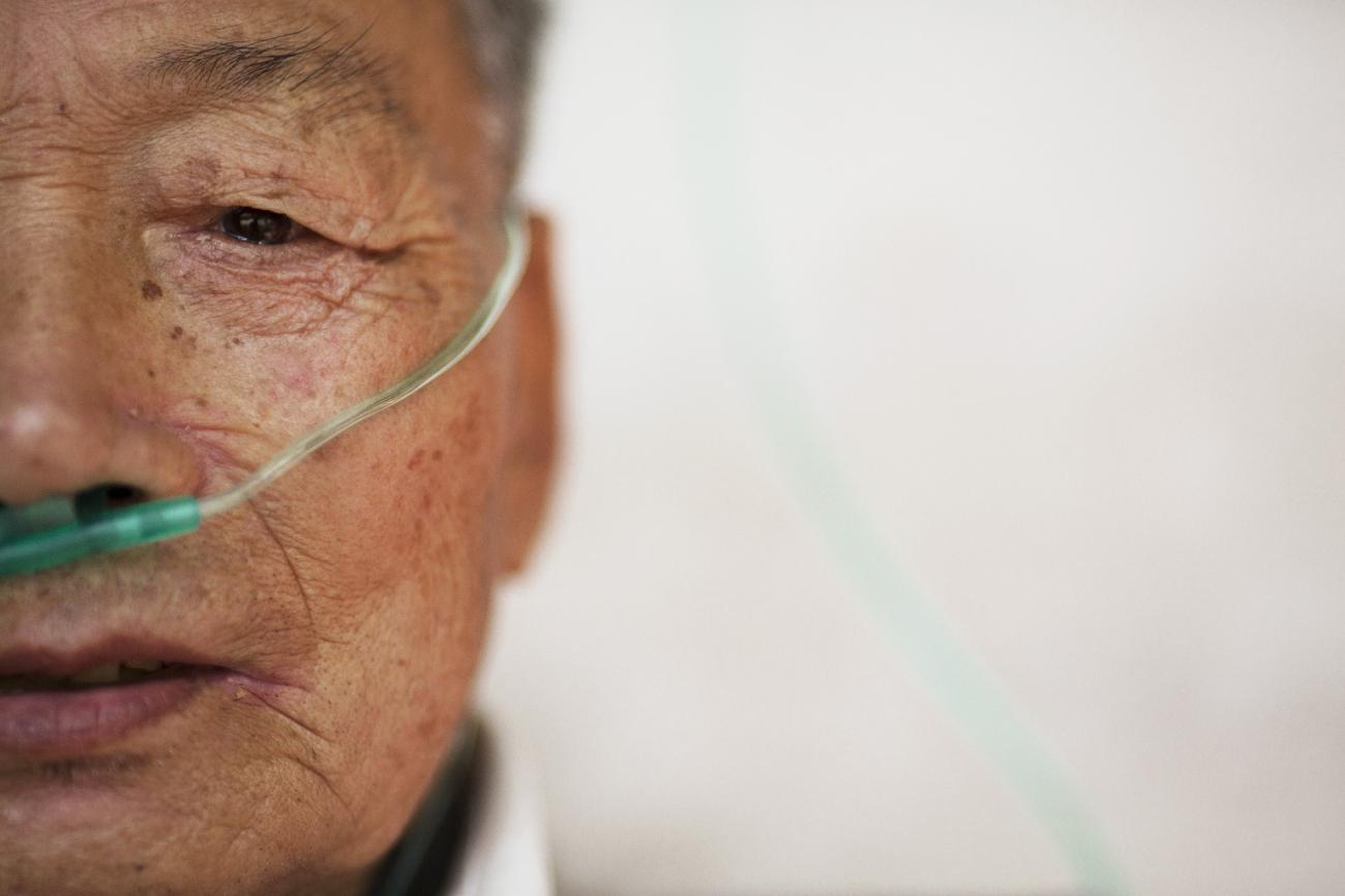 Hu Hushen, a 78 year old former miner, breathes using a nasal cannula for oxygen supply outside his room at Yangjia Hospital in Wuyi County, Zhejiang Province, China October 19, 2015. 