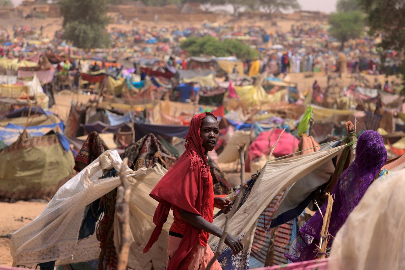 A Sudanese girl moves past makeshift shelters near the border between Sudan and Chad, while taking refuge in Borota, Chad, May 13, 2023.