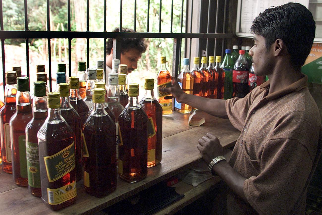 Man selling alcohol from a window.