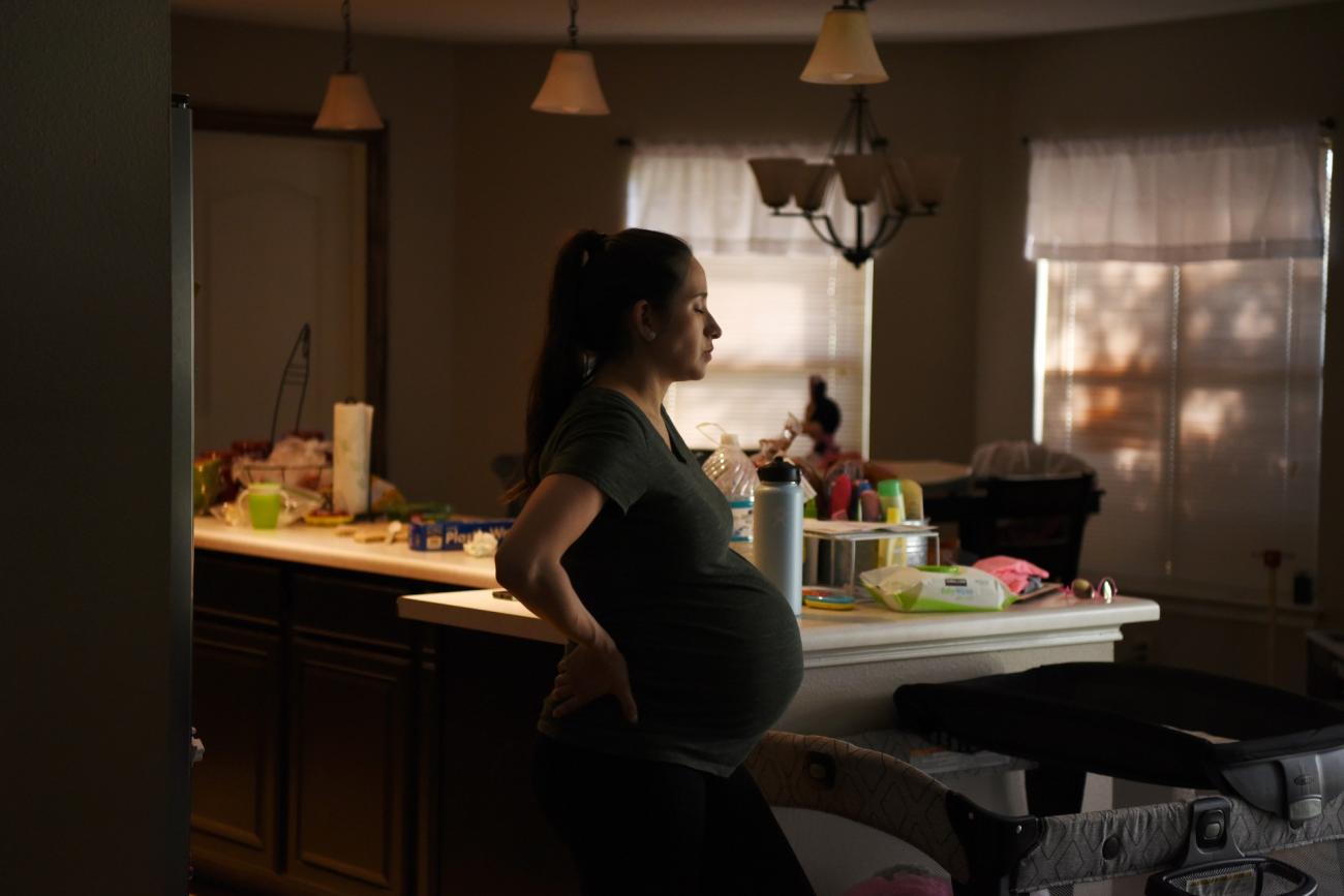 Pregnant woman stands in her kitchen in San Antonio, Texas, on May 6, 2020.