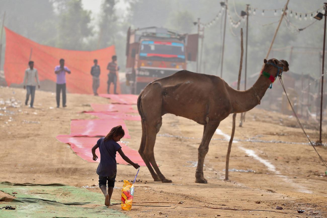 A girl plays with a deflated balloon as she walks through smog in Delhi, India November 7, 2016.