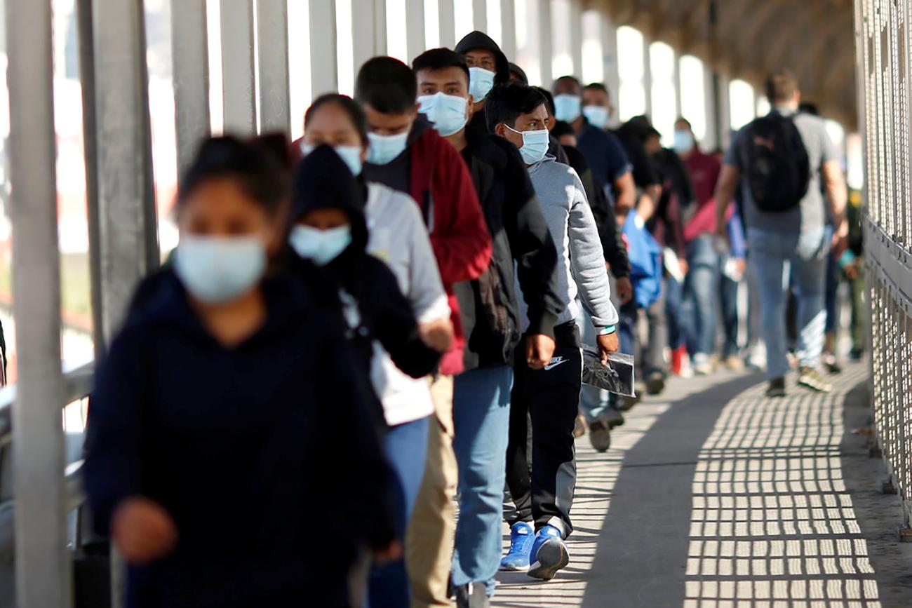 Migrants expelled from the U.S. and sent back to Mexico under Title 42, walk towards Mexico at the Paso del Norte International border bridge.