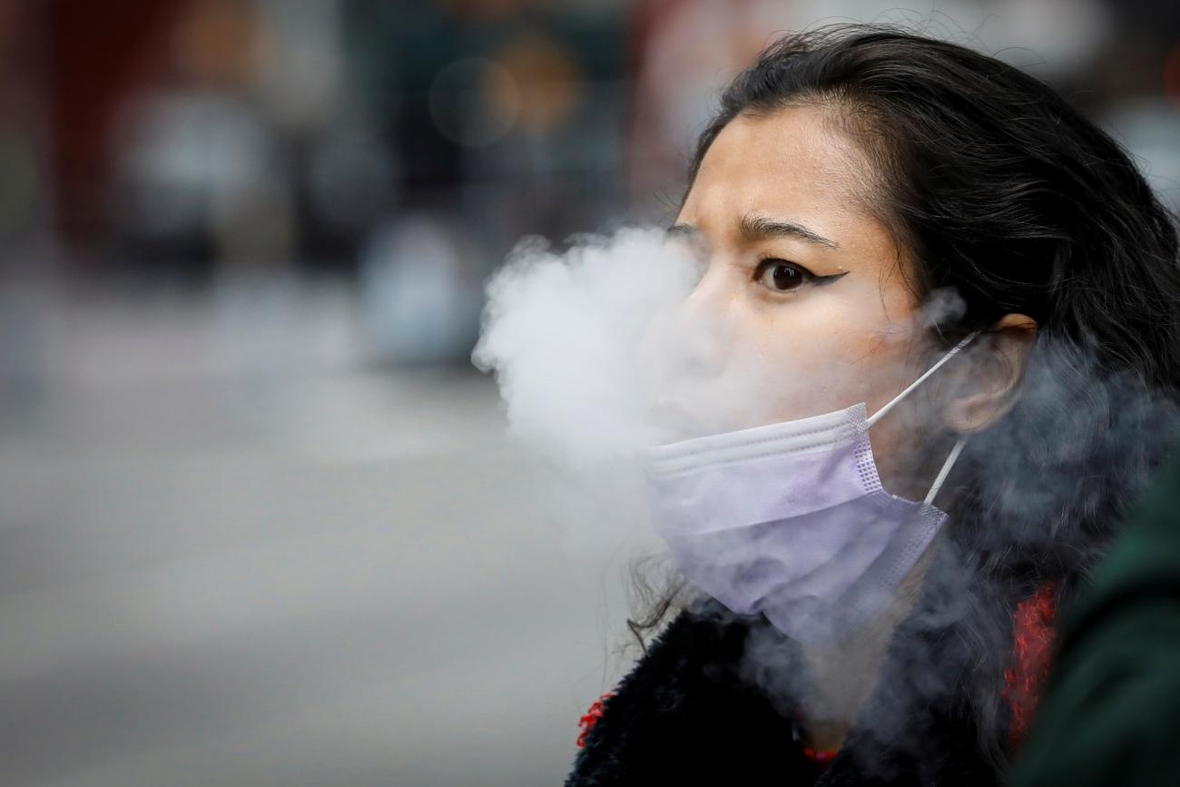 A woman exhales after vaping in Times Square, during the coronavirus disease (COVID-19) outbreak, in New York City, U.S., March 31, 2020. 