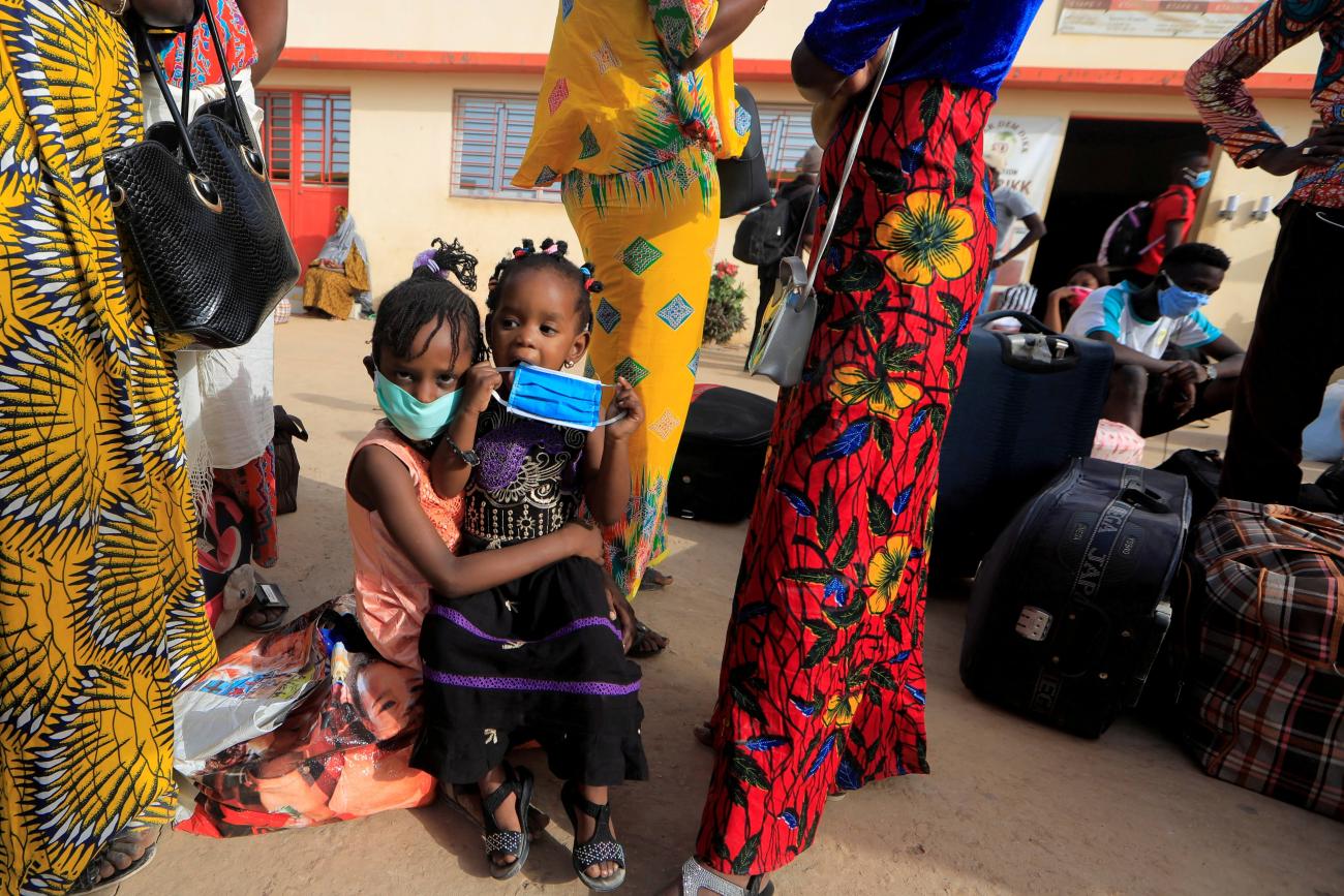 Teachers and their children wait to board a government chartered bus bringing people back to schools of countryside towns in Dakar, Senegal on May 28, 2020.