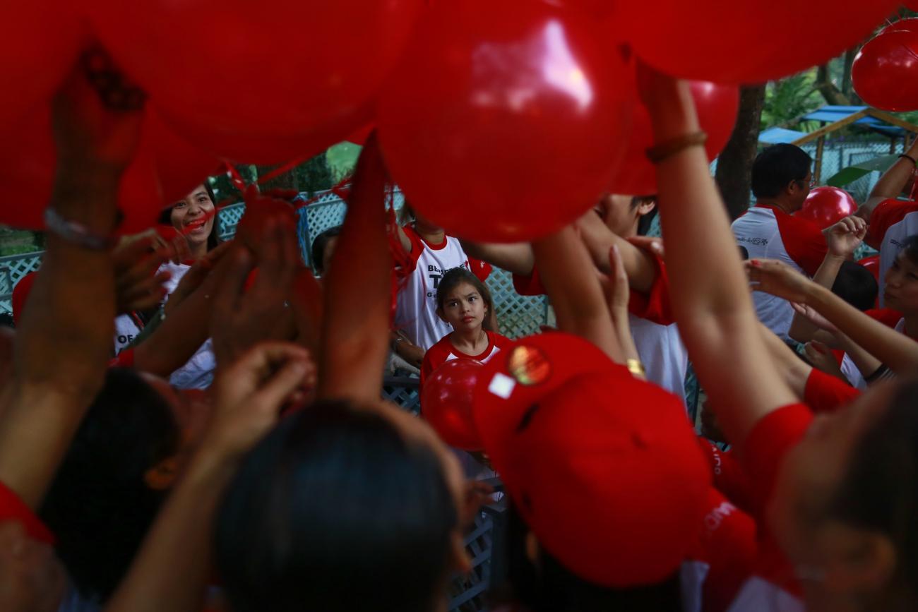 People take balloons before a march ahead of World AIDS Day 2013 at Kandawgyi garden in Yangon November 30, 2013. About one thousand people, including HIV/Aids patients, attended the event.