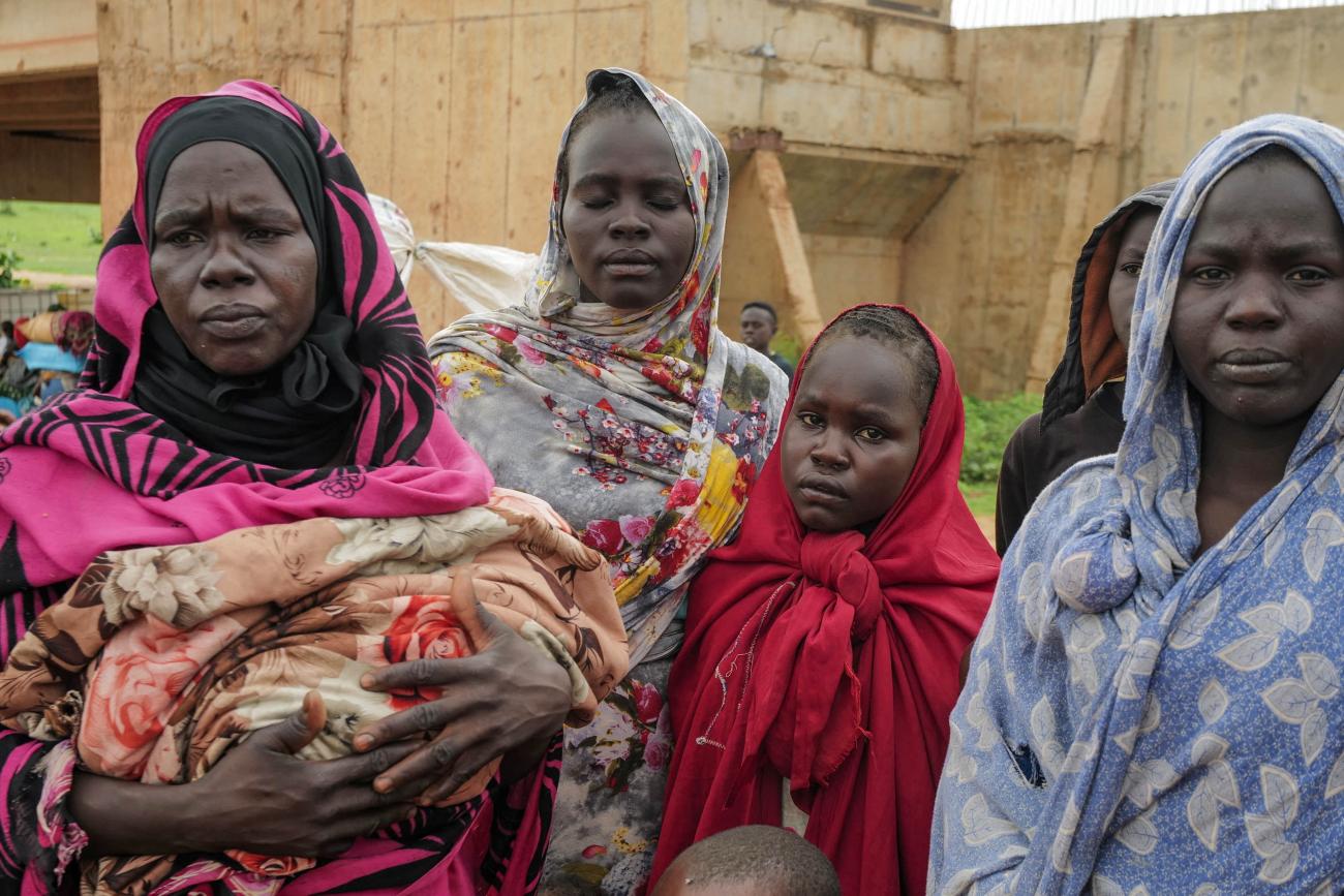 Sudanese women, who fled the conflict in Murnei in Sudan's Darfur region, look on while crossing the border between Sudan and Chad.