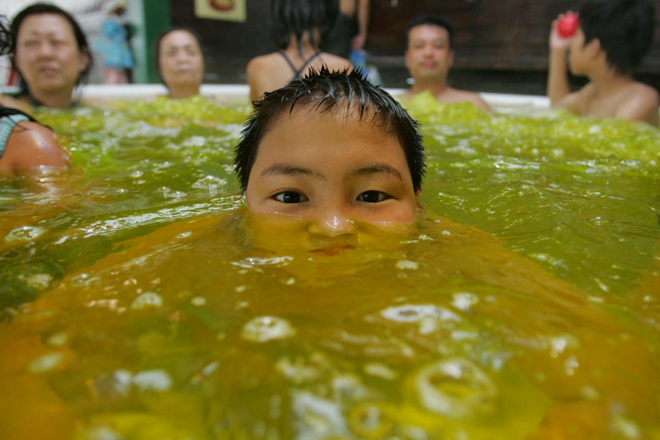 A boy soaks himself in a hot bath infused with curry spices to improve blood flow and the appearance of skin.