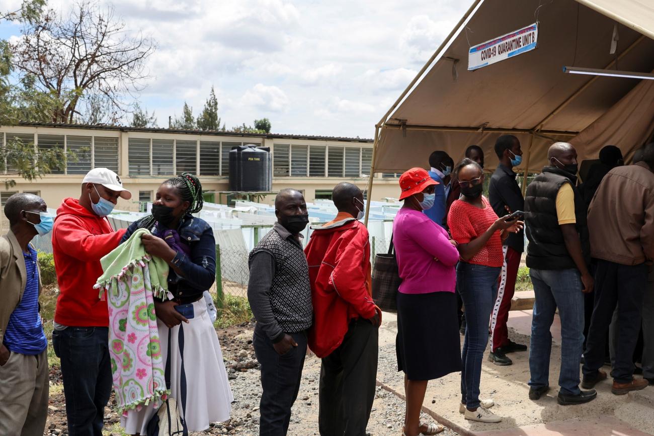 People stand in line to receive a COVID-19 vaccine, at the Narok County Referral Hospital.