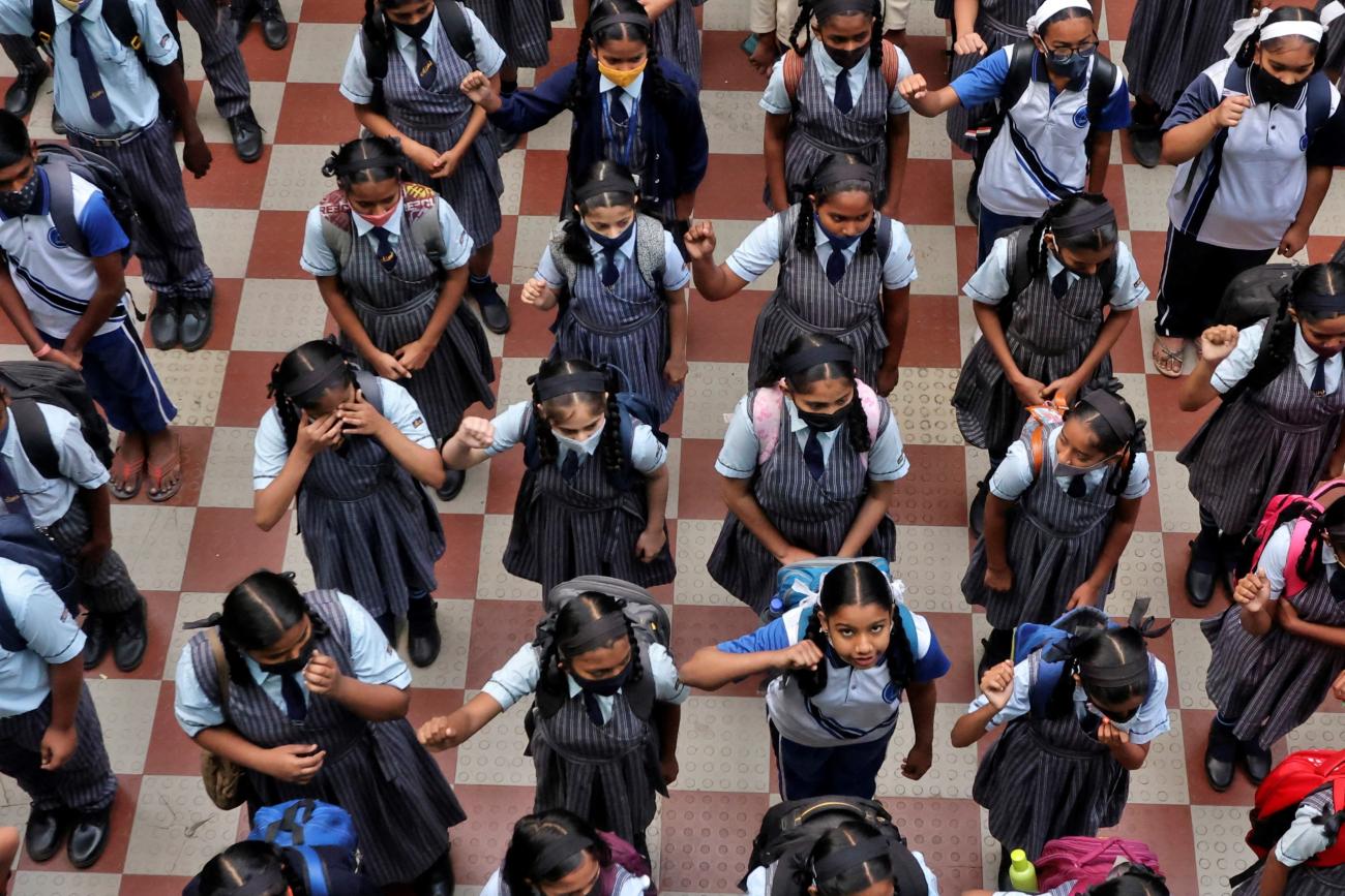 Children assemble for morning prayers after schools reopen with full capacity following their closure due to COVID-19.