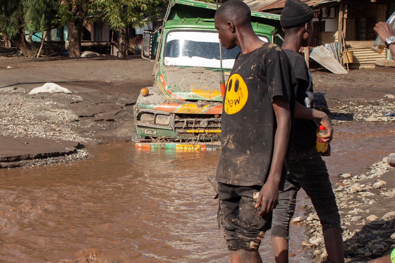 A person looks at a road that was washed away in a flash flood.