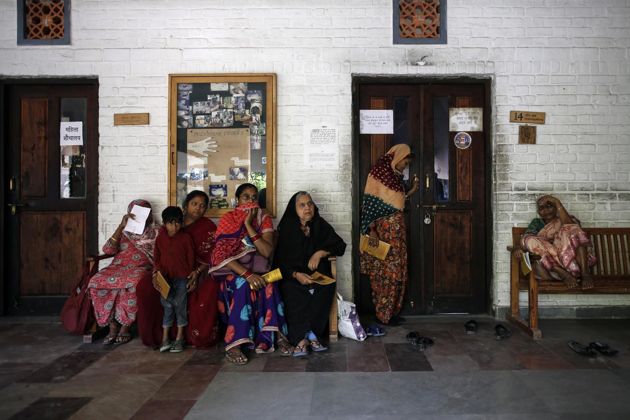 People wait to receive medicine at a clinic.