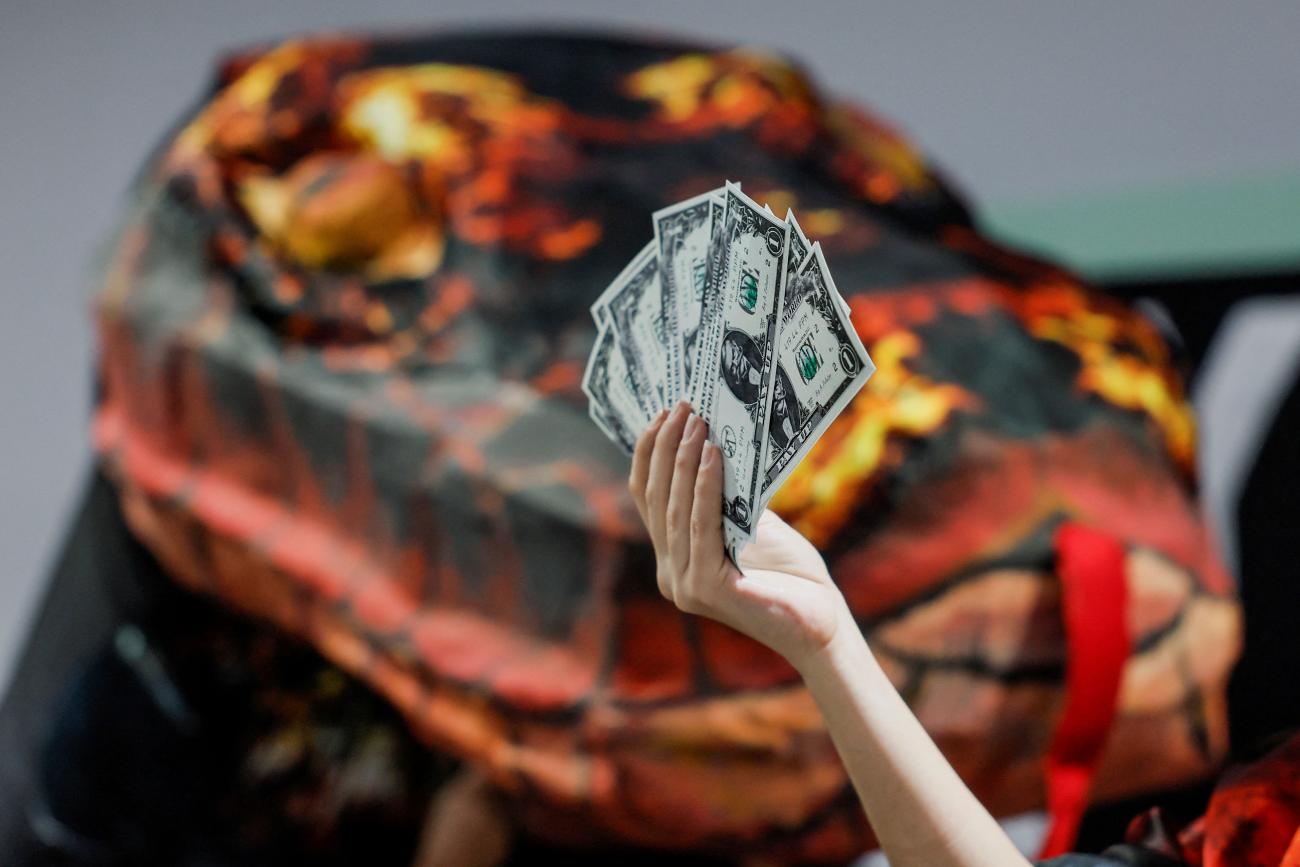 an activist holds up fake currency bills