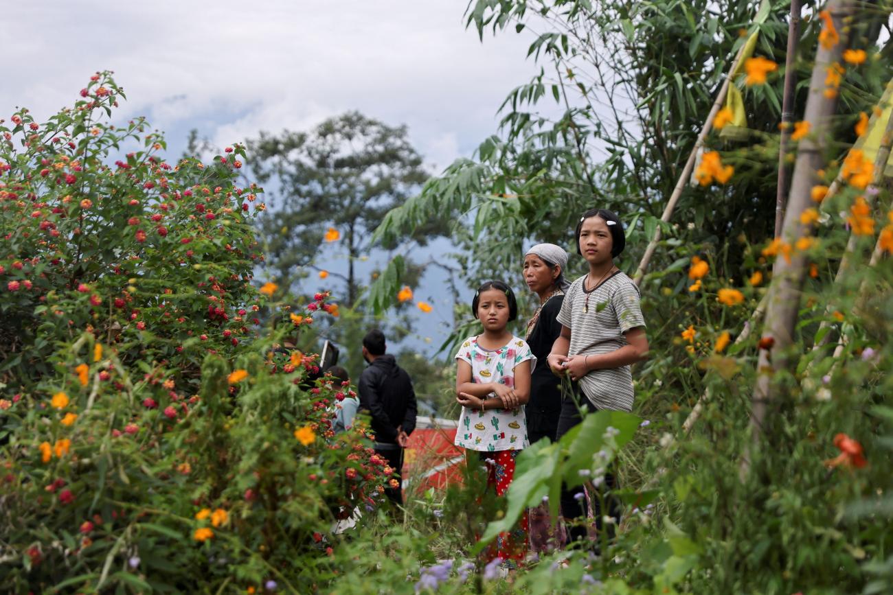 People watch as relief materials are loaded onto a helicopter to be delivered to inaccessible areas after flash floods caused by a lake burst, in Sikkim, India, on October 9, 2023.