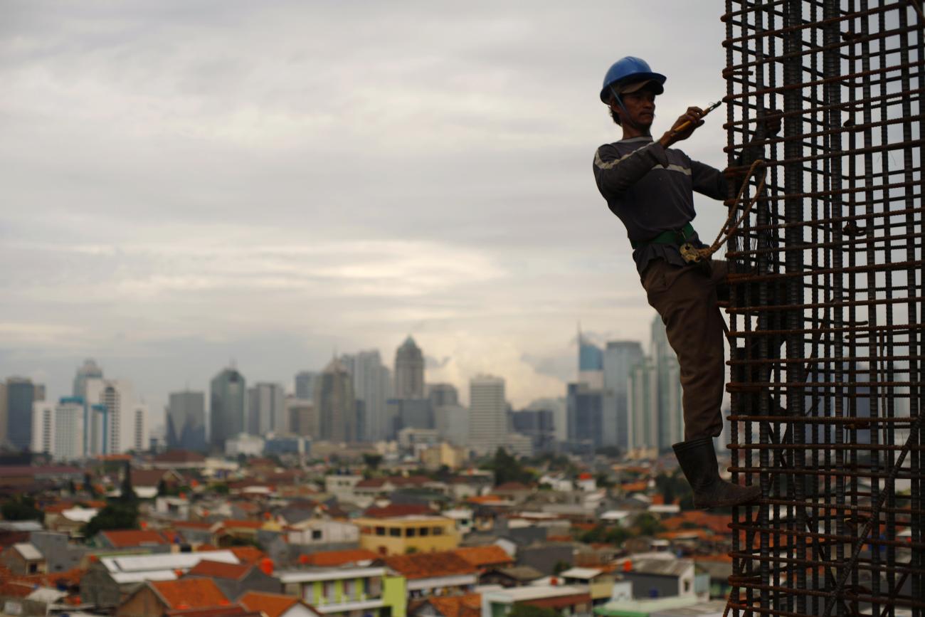A worker stands on steel rods at a construction site, Jakarta, Indonesia, on February 2, 2010. 