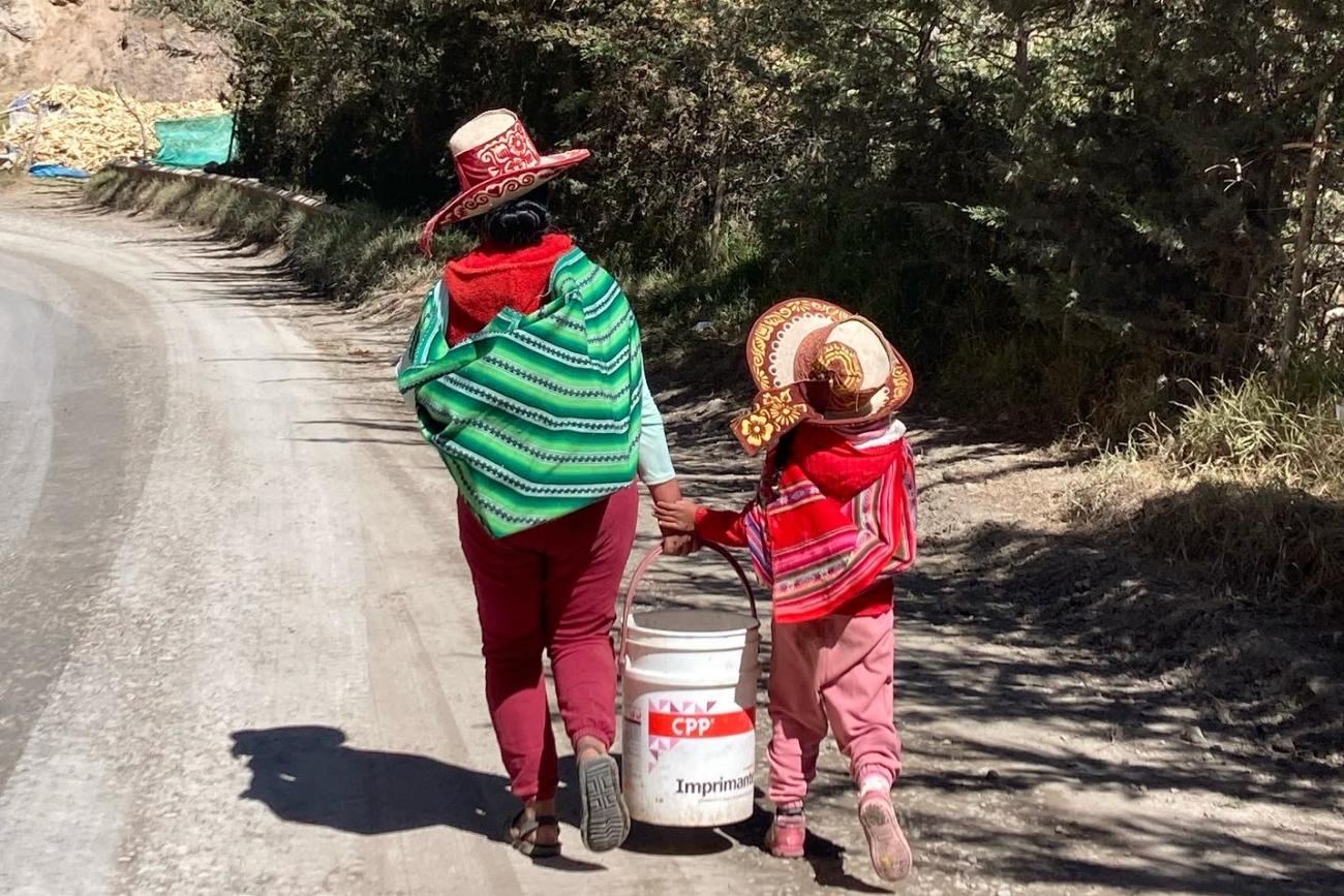 A mother and her daughter carry grain to their home in rural Cusco, Peru, on July 21, 2022