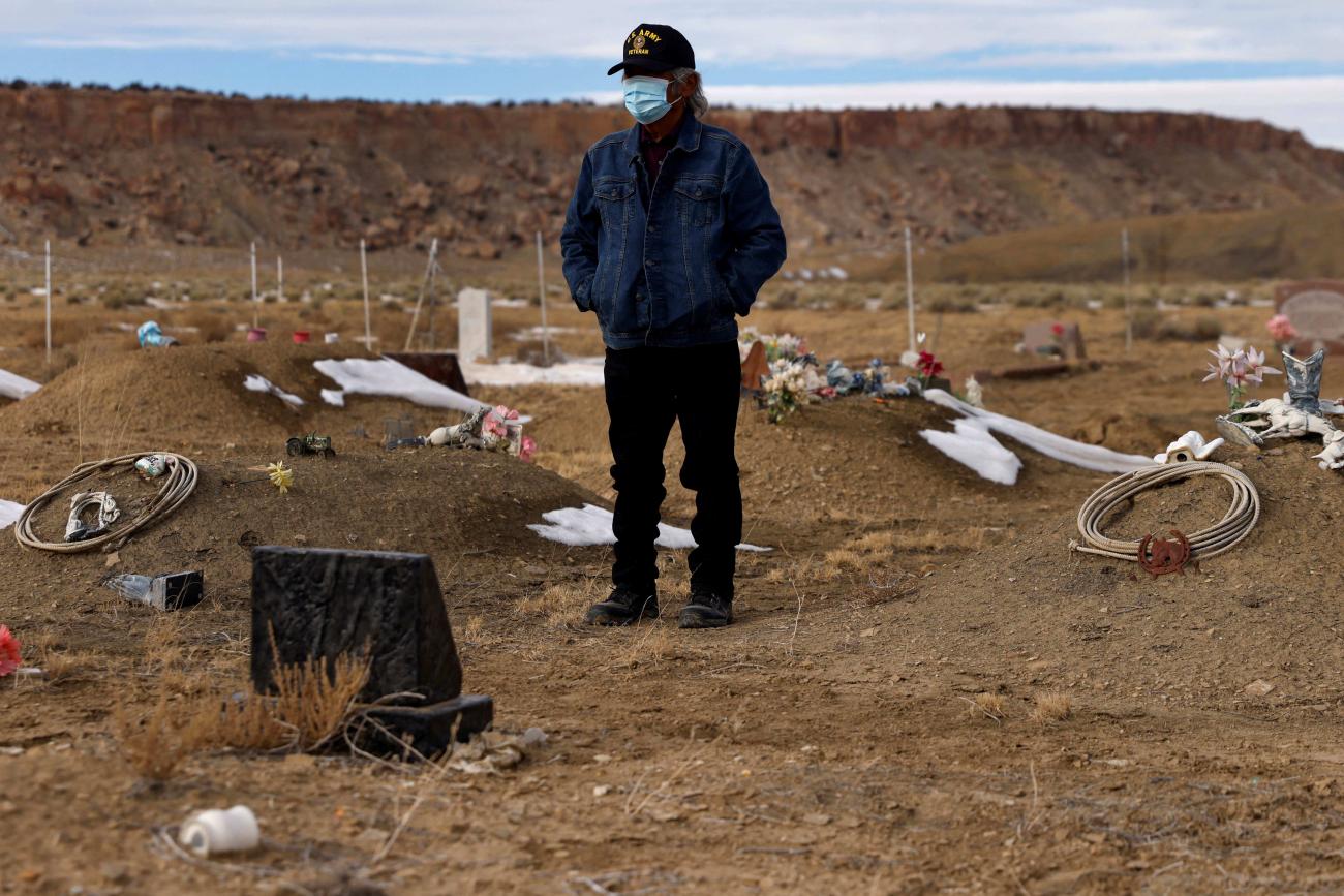 Wallace Buck stands alone waiting for the burial of his sons, who both died from complications of COVID-19, at the Sanostee chapter of the Navajo nation, in New Mexico, on December 16, 2021.