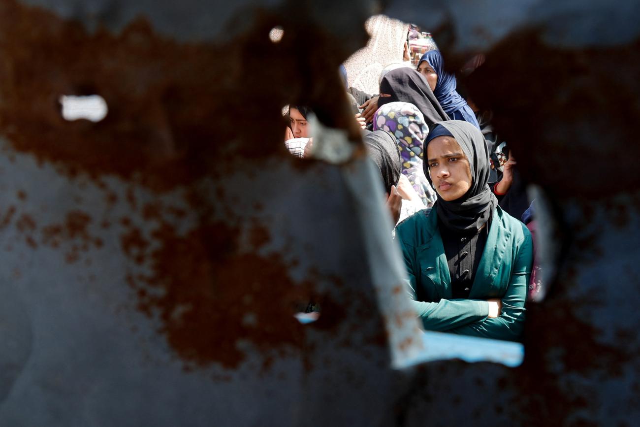A Palestinian woman looks on as she and others gather to receive bread from a bakery, in Khan Younis, Gaza Strip, on March 9, 2025.