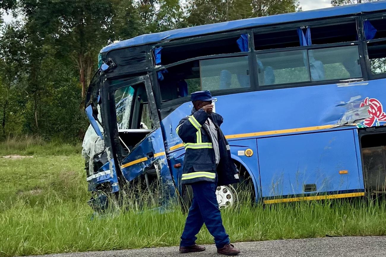 A man walks away from a bus that was involved in a disastrous head-on collision with tractor-trailer, in Macheke, Zimbabwe, in January 2024. 