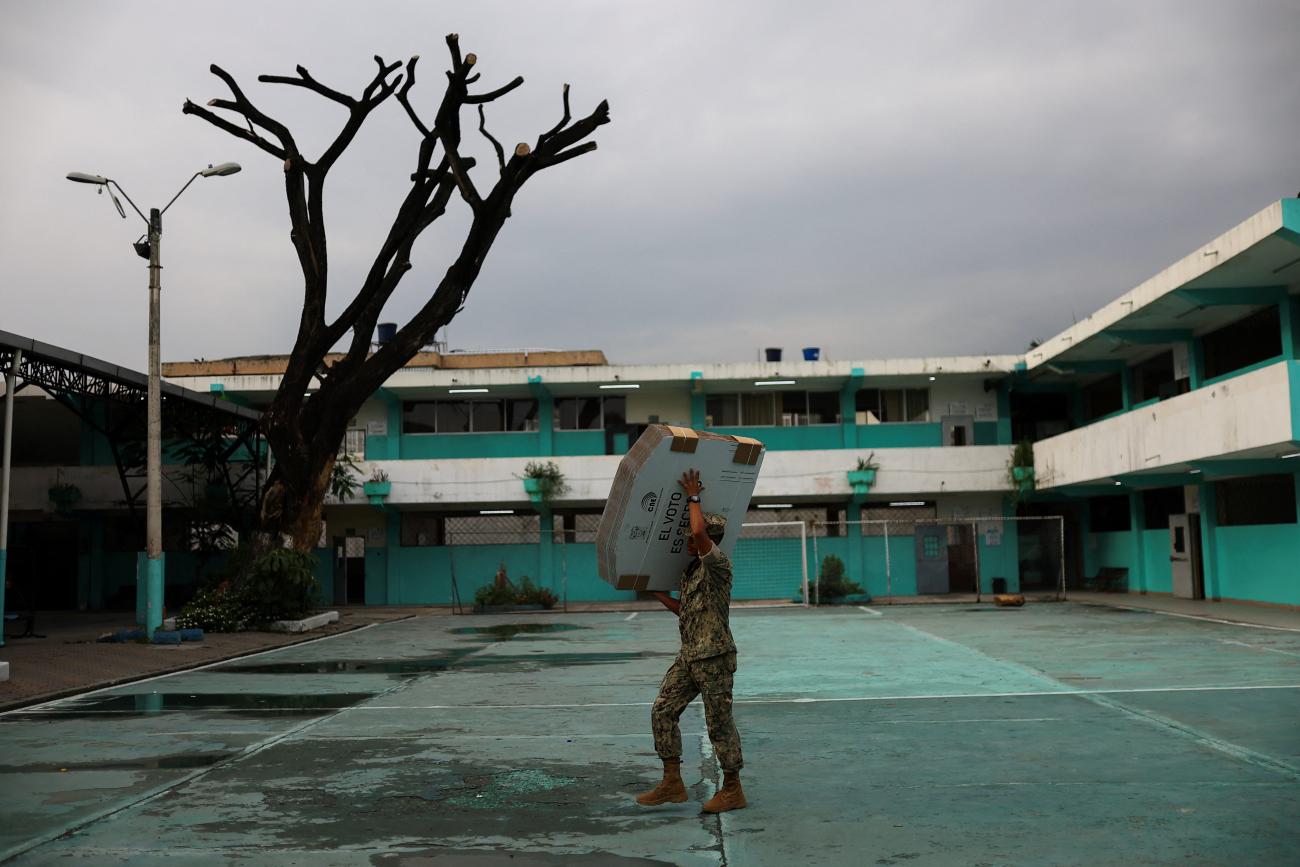 A member of the Navy carries electoral material out to a school that is being used a polling station ahead of the presidential election, in Guayaquil, Ecuador, on February 8, 2025. 