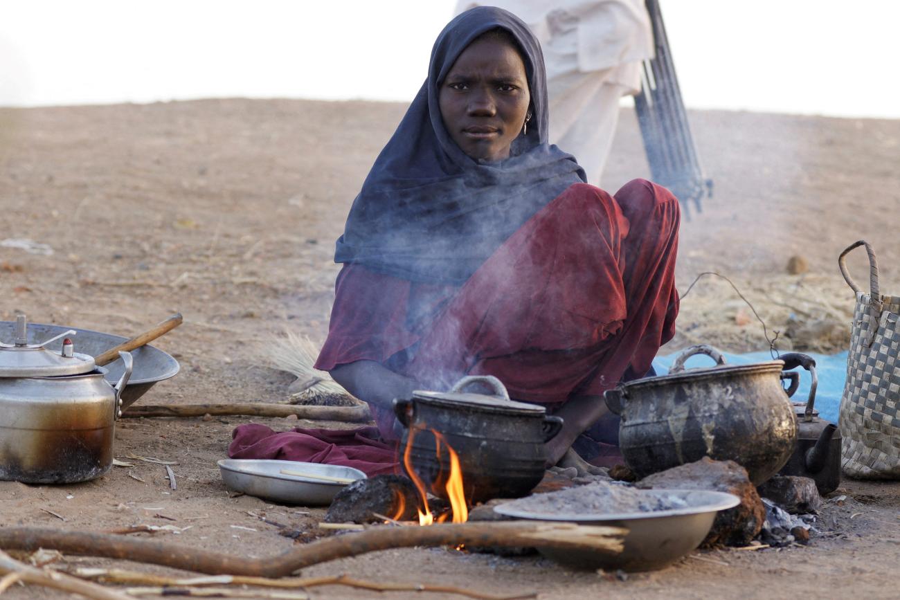 A displaced woman prepares food, following Rapid Support Forces attacks on Zamzam displacement camp, as she shelters in the town of Tawila, in North Darfur, Sudan, on April 16, 2025.