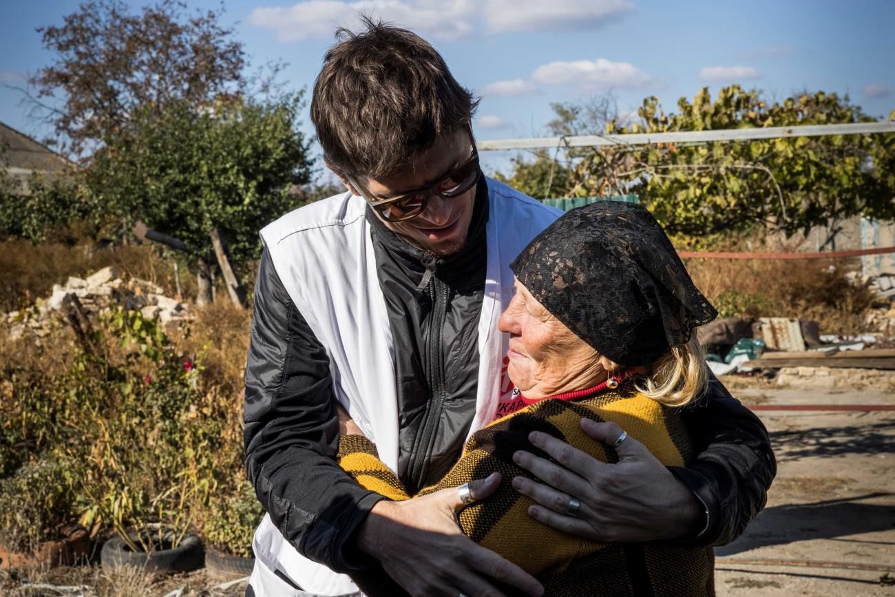 A Doctors without Borders employee supports a woman in Mykolaiv, Ukraine after a Russian missile destroyed her house, October 10, 2023.