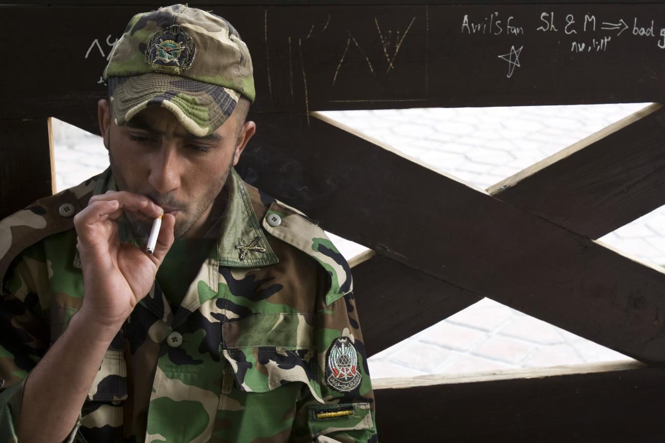 A member of the Iranian army smokes as he rests at a park in central Tehran, April 9, 2009