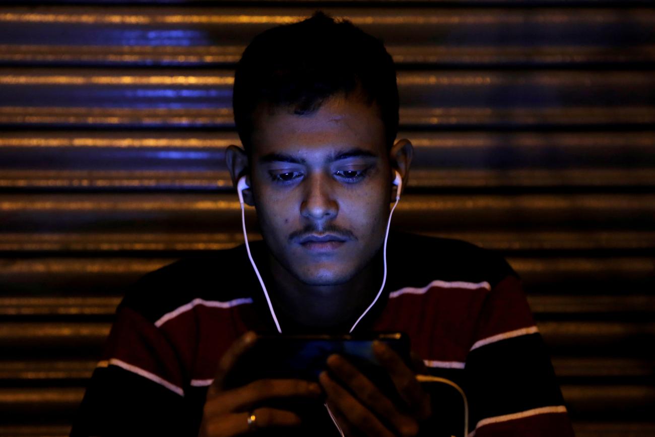 A man watches a movie on his phone, in Delhi, India, on November 16, 2016.