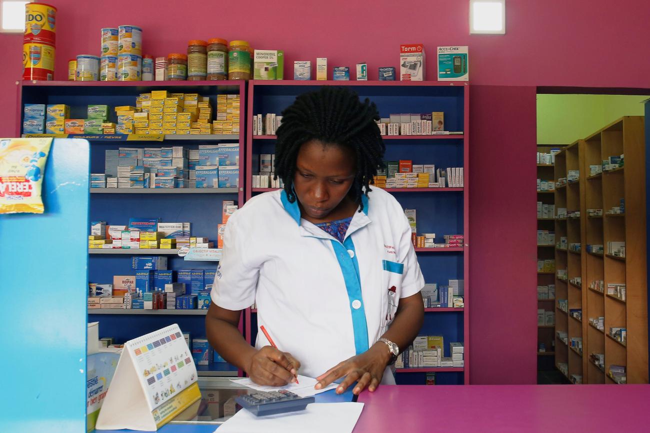 A vendor writes as she stands in a legal pharmacy, in Abidjan, Ivory Coast, on October 16, 2018. 
