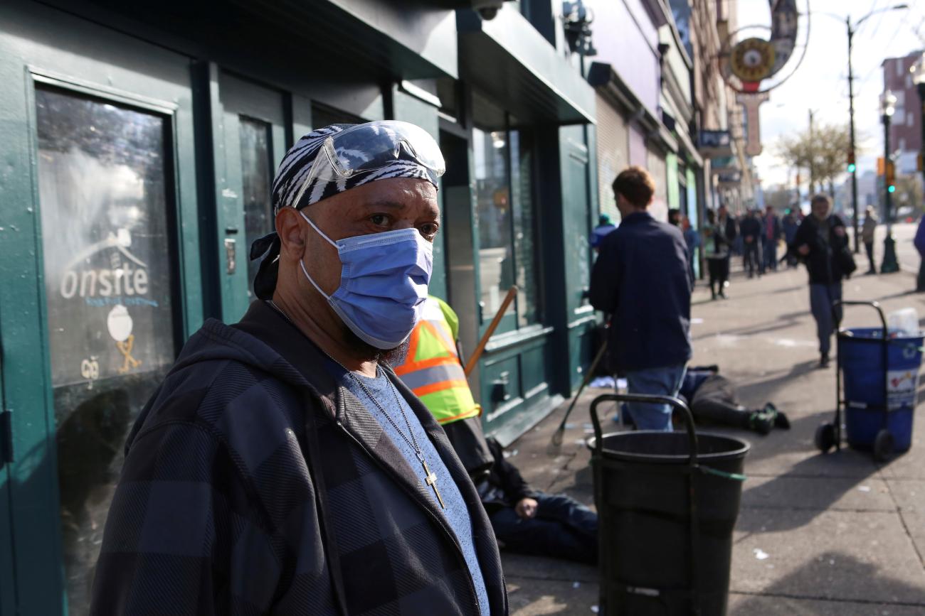 An InSite staff member directs drug users outside the supervised injection site on Hastings Street, in Vancouver, British Columbia, Canada, on March 25, 2020. 