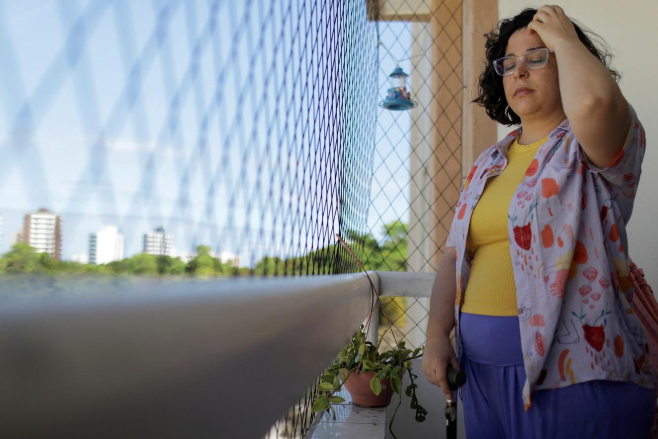 Leticia de Souza Soares, who suffers from pain and health problems caused by long COVID-19, stands on the balcony of her home, in Salvador, Brazil, on December 8, 2023. 