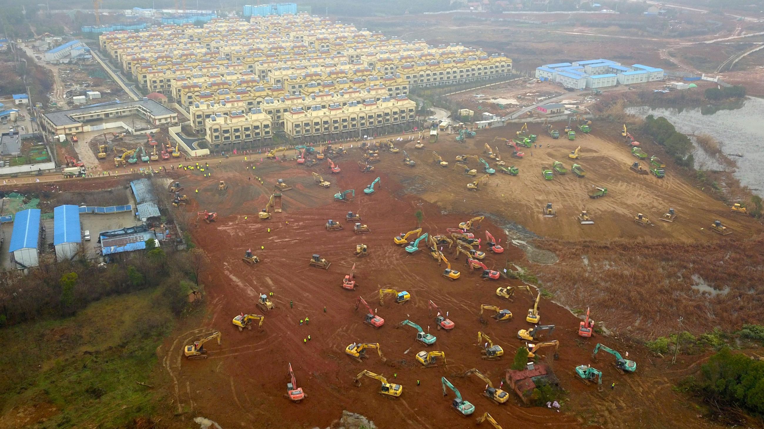 Picture shows a field from a high shot, presumably taken from a plane, with a field cleared of groundcover and dozens of land moving machines busy working. 